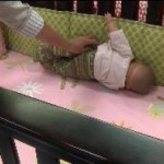 A doll shows how a real infant can suffocate on crib bumper pads